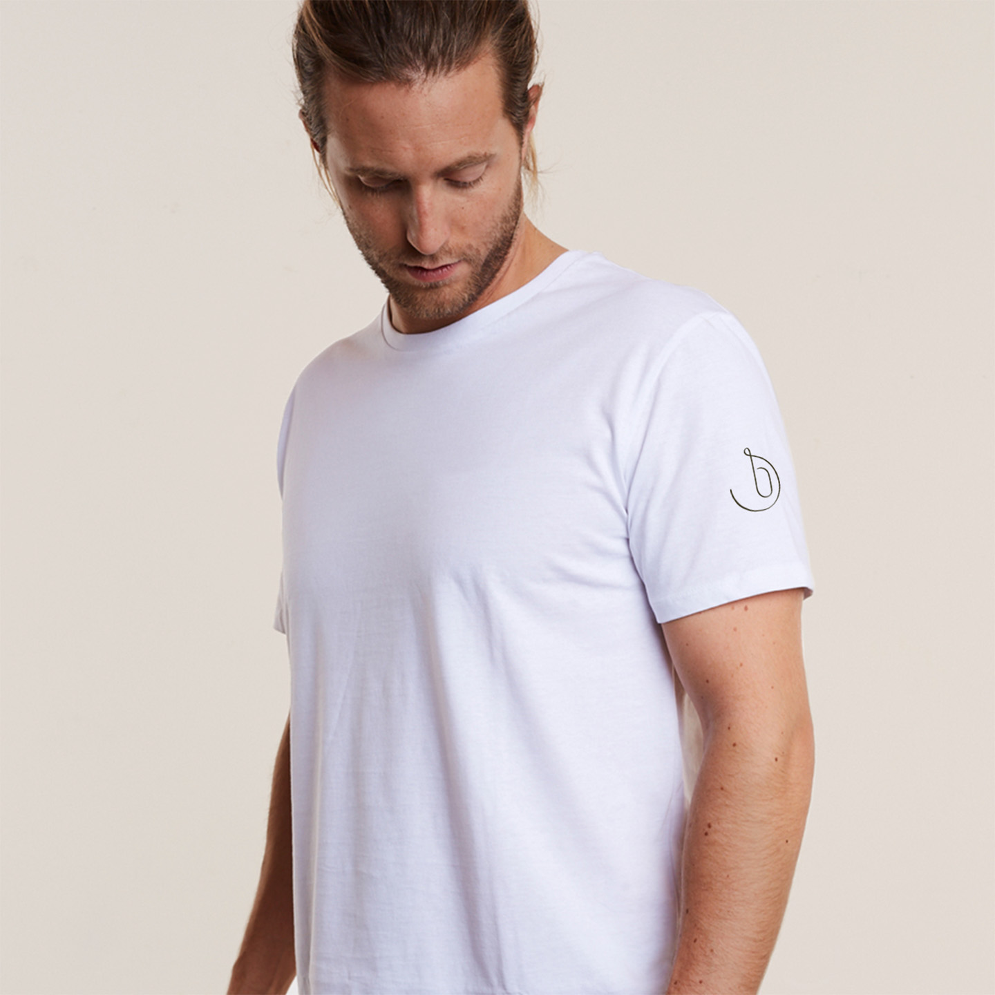 man with a branded t-shirt showcasing the monogram logo on his shoulder