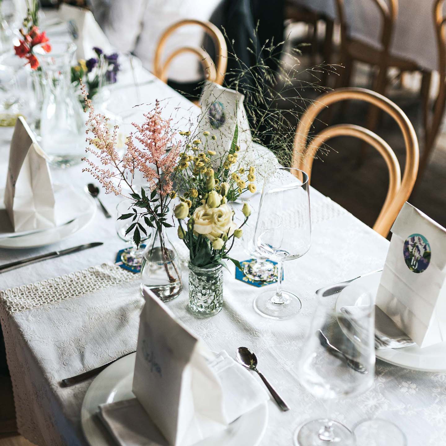 set table at a wedding with flowers, coasters and giveaways