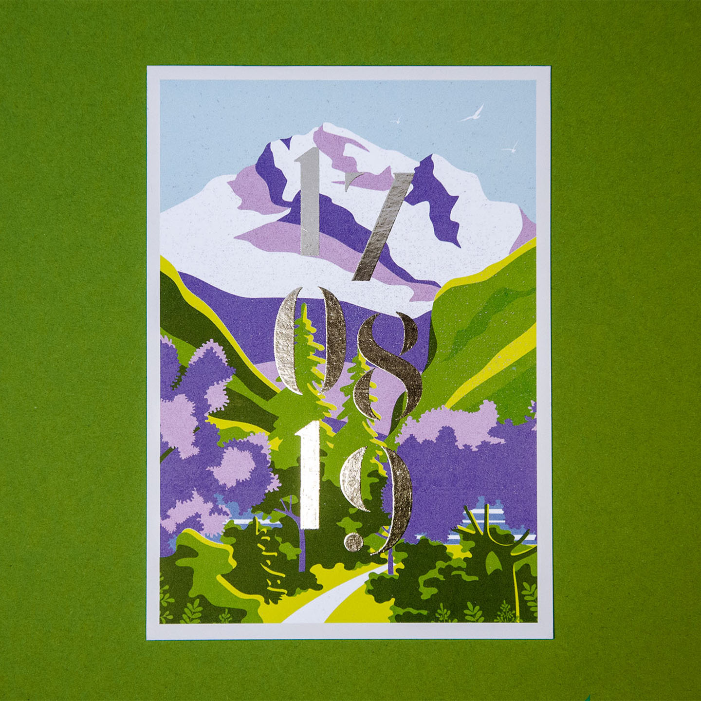 postcard with mountain illustration and silver cold foil lettering of a stencil font