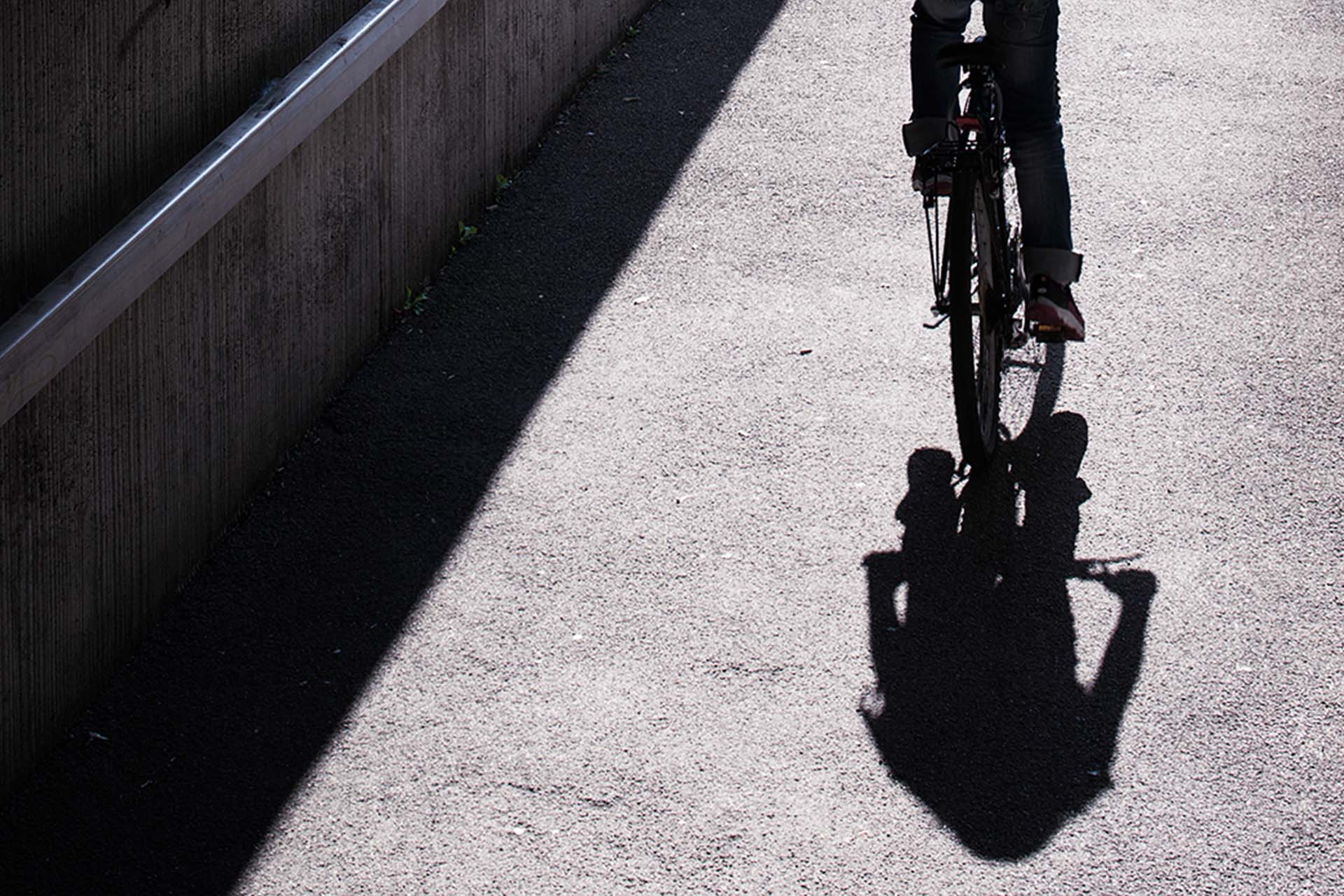 Asphalt path with shadow figure on bicycle
